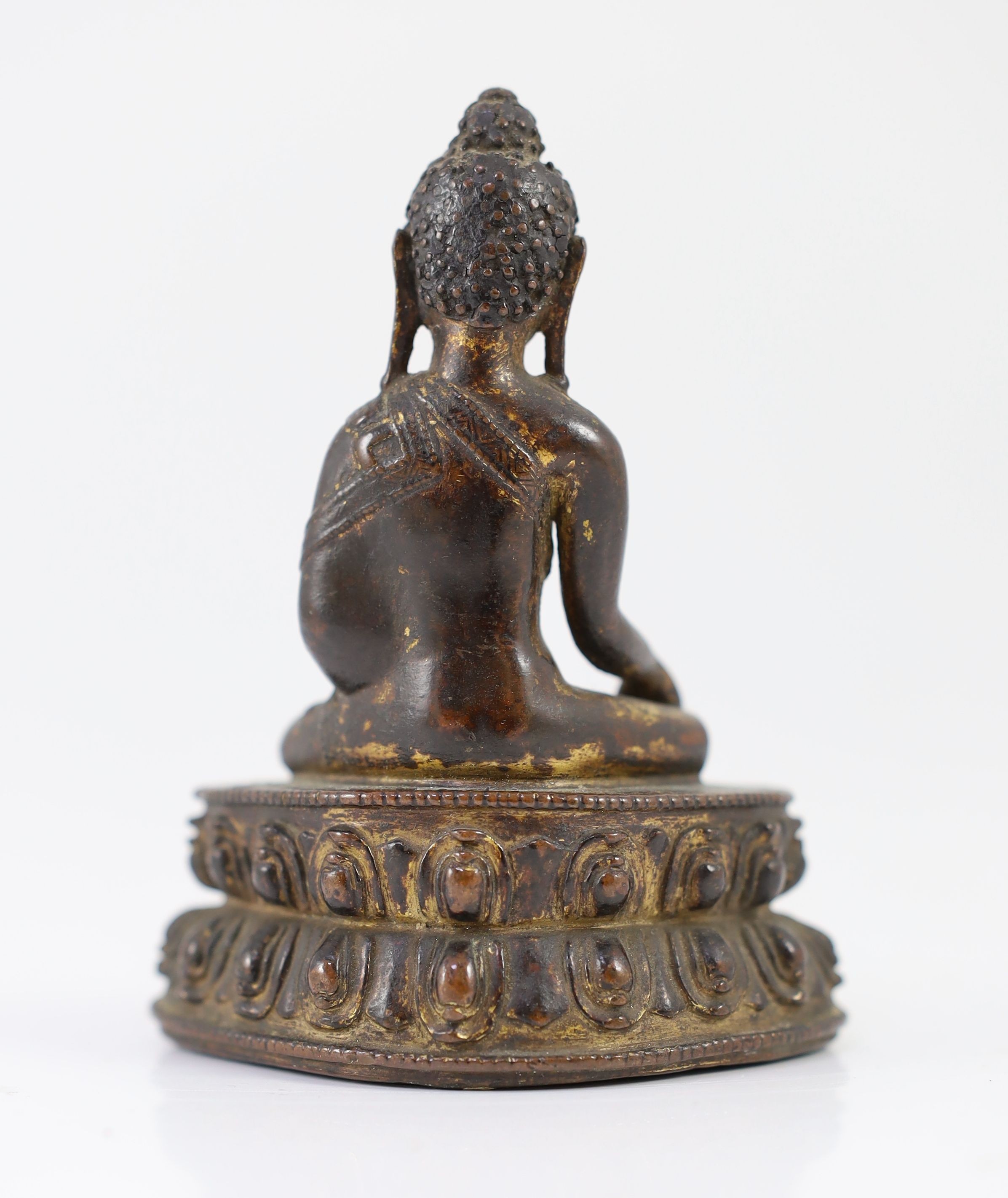 A small Tibetan gilt copper alloy seated figure of Buddha Shakyamuni, probably 15th/16th century, 10.4cm